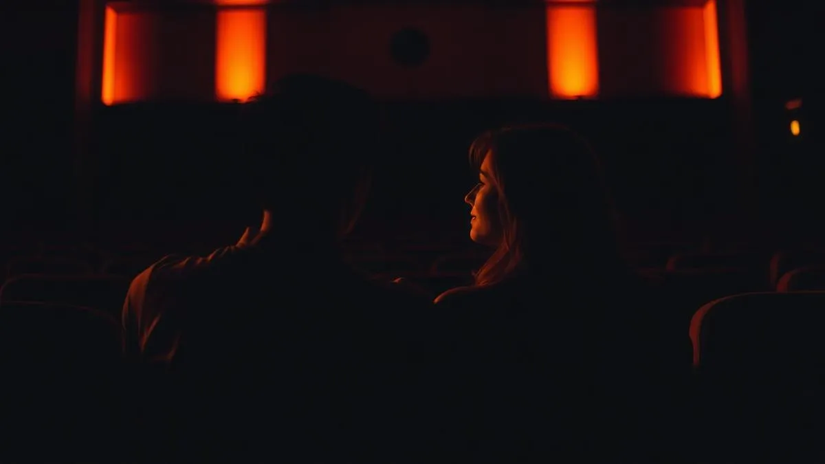 Couple dans une salle de cinéma dans une ambiance tamisée et romantique